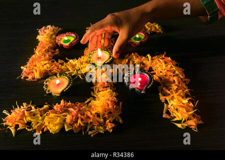 Ein Mädchen Beleuchtung diyas für Feiern Diwali und dhanteras Festival in Indien Stockfoto