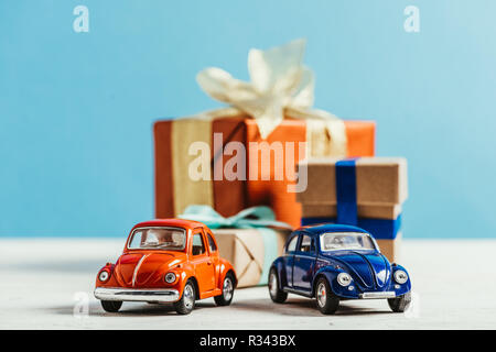 Nahaufnahme von Spielzeugautos mit Weihnachten Geschenkboxen auf blauem Hintergrund Stockfoto