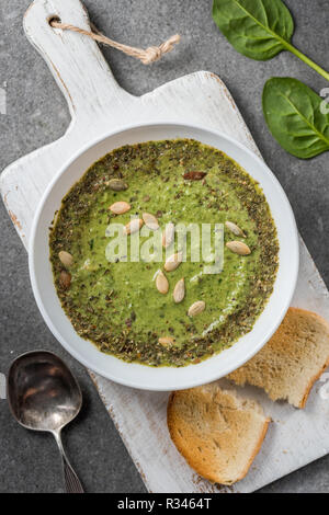 Blick von oben auf die hausgemachte Gemüse cremige Suppe mit Scheibe Brot auf Schneidebrett Stockfoto