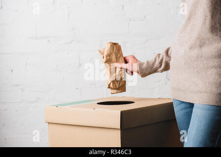 Teilweise mit Blick auf die Frau werfen Papier in den Papierkorb Stockfoto