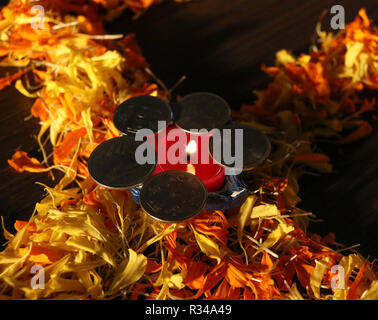 Lit diya auf Blume mit Münzen für Feiern Diwali und dhanteras Festival in Indien Stockfoto