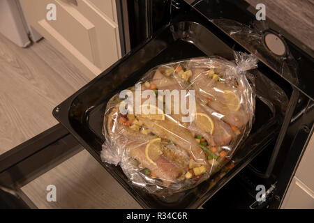 Weißer Fisch mit Zitrone und Gemüse in der Hülse für das Backen Stockfoto