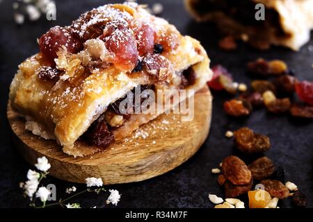 Verstorbenen Strudel. Eine Mischung aus getrockneten Früchten und Nüssen in Blätterteig und gebacken, bis sie goldbraun sind. Schuß auf eine Achterbahn mit Zutat Requisiten genommen Stockfoto