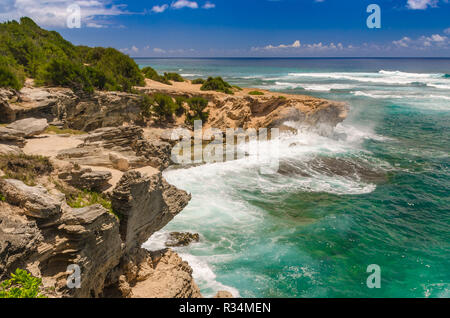 Die Wellen schlagen auf die felsige Küste entlang eines Abschnitts der Mahaulepu Heritage Beach Trail in Kauai, Hawaii, USA Stockfoto