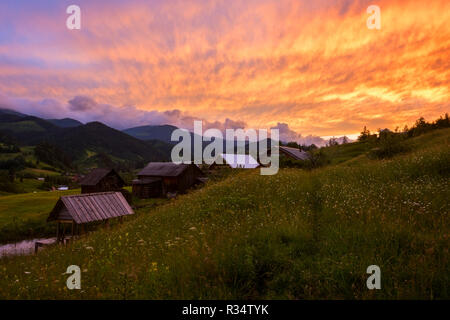 Feurigen Sonnenuntergang über die Alpine Village, Natur Landschaft. Karpaten-biosphärenreservat Stockfoto