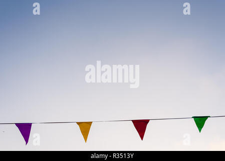 Bunte Girlanden winken im Wind vor blauem Himmel ideal zum Dekorieren ein Geburtstag. Stockfoto