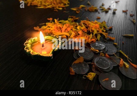 Lit diya mit Blumen und Münzen für diwali und dhanteras Feier in Indien eingerichtet Stockfoto