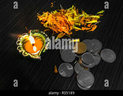 Lit diya mit Blumen und Münzen für diwali und dhanteras Feier in Indien eingerichtet Stockfoto