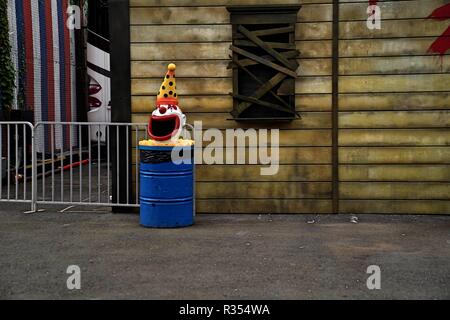 Eine gespenstische clown Kopf sitzt auf einem abfallkorb Stockfoto