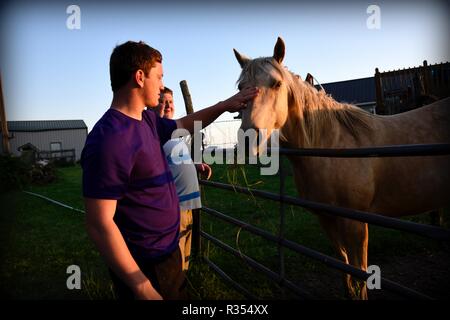 Ein junger Mann hängt heraus mit seinem Pferd Stockfoto