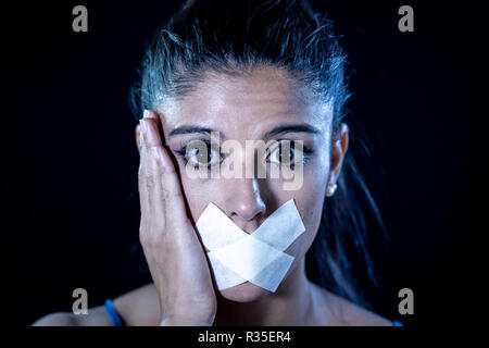 Attraktive angst Frau mit Getapten Mund in Schweigen Missbrauch Zensur auch Mich und die Freiheit der Rede Konzept isoliert auf schwarzen Hintergrund. Stockfoto