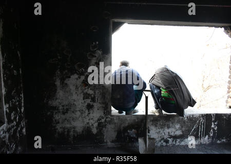 Pulwama, Indien. 20 Nov, 2018. Kaschmir muslimischen Menschen bewerten die Beschädigung eines Wohnhauses, die während einer Begegnung zwischen Indien und Kaschmir Rebellen in Shopian Distrikt des indischen verwalteten Kaschmir am 20. November 2018 beschädigt wurde. Vier Rebellen wurden in eine Schießerei zwischen indischen Kräfte und Kaschmirischen Rebellen, die als Inam ul Haq von Feripora, Abid Nazir Chopan von Paddarpora, Mehraj ud Din Najar von Drawni Zainapora und Basharat Ahmad von Chotigam identifiziert wurden getötet. Zwei indische Fallschirmjäger wurden auch bei der Schießerei getötet. Credit: Muzamil Mattoo/Pacific Press/Alamy leben Nachrichten Stockfoto