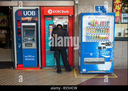 22.02.2018, Singapur, Republik Singapur, Asien - ein Mann zieht sich Geld aus einem Geldautomaten in der Innenstadt von Singapur. Stockfoto