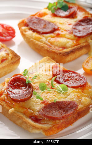 Toast mit geschmolzenem Käse und Bratwurst, Frühstück auf der Platte Stockfoto