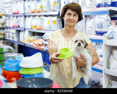 Feine Frau besuchen Pet Shop auf der Suche nach Dog Bowl für die Fütterung Ihres süssen Havaneser Stockfoto