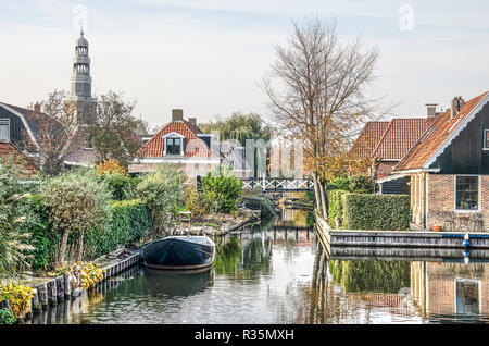 Sneek, Niederlande, November 4, 2018: Dorf - wie Szene in der Altstadt mit einem schmalen Kanal, Häuser und Hinterhöfe und der Turm des Heiligen Ge Stockfoto