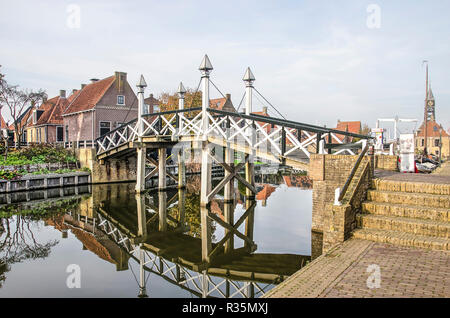 Sneek, Niederlande, November 4, 2018: hölzerne Fußgängerbrücke in der Mirrorlike Oberfläche eines Kanals in der Altstadt widerspiegelt Stockfoto