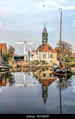 Sneek, Niederlande, November 4, 2018: die Schleuse keepers Haus mit seinem Turm, der angrenzenden Brücke und einem traditionellen Barge spiegeln sich in der mi Stockfoto