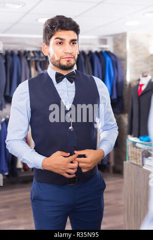 Shopper versucht, der auf ausgewählten Bild vor dem Spiegel in der Männer Shop. Stockfoto