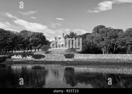 Sehenswürdigkeiten und Attraktionen. Lews Castle in Stornoway, Großbritannien vom Meer Hafen gesehen. Schloss mit grüne Gelände am blauen Himmel. Hotel im viktorianischen Stil, Architektur und Design. Sommer Urlaub und Fernweh. Stockfoto