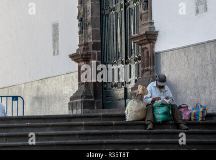 Ein Landwirt aus dem Markt sitzt auf den Stufen der Basilika Nuestra Señora de la Merced in Quito, Ecuador Stockfoto