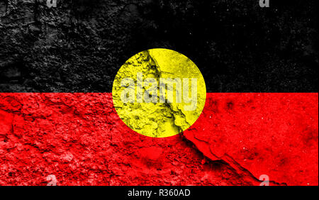 Flagge der Aborigines in der Nähe auf einen Riss in der Wand, Konzept der bewaffneten Aktionen und Konflikte in der Welt lackiert Stockfoto