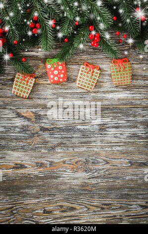 Weihnachten Hintergrund mit Lebkuchen in Form von Geschenken und Tannenbaum auf rustikalen Holztisch. Ansicht von oben. Kopieren Sie Platz. Stockfoto
