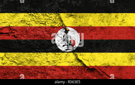 Flagge Uganda schließen bis auf einen Riss in der Wand, Konzept der bewaffneten Aktionen und Konflikte in der Welt lackiert Stockfoto