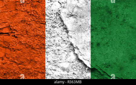 Flagge von Cote d Ivoire schließen bis auf einen Riss in der Wand, Konzept der bewaffneten Aktionen und Konflikte in der Welt lackiert Stockfoto