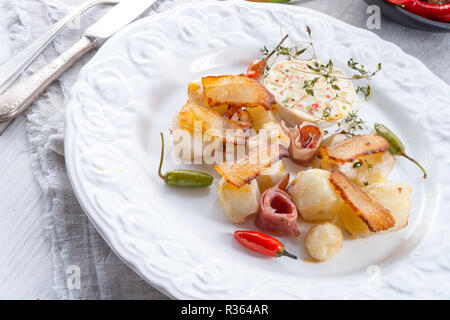 Topinambur gratiniert mit Schinken und Chili Stockfoto