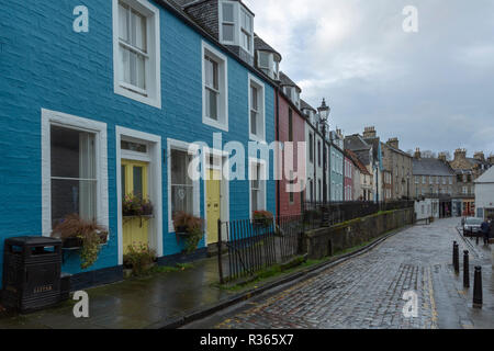 Bunten Reihenhäuser auf einer gepflasterten Straße in South Queensferry, Edinburgh. An einem regnerischen Tag. Stockfoto