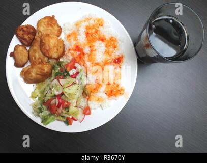 Huhn auf einem Teller mit Reis und Salat, Schuß von oben Stockfoto