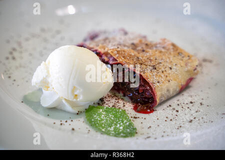 Closeup Bild eines leckere Pfannkuchen mit Eis und Erdbeere Sirup alle über der Platte Stockfoto
