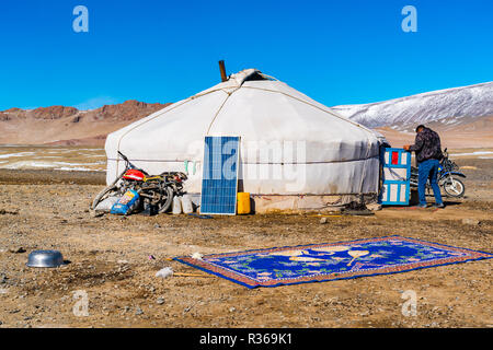 Mann, der in die mongolischen Ger in einer großen schneebedeckten Steppe in der Nähe von einem Berg bei der Stadt Chowd in der Mongolei Stockfoto