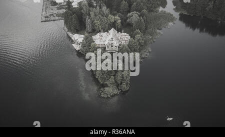 Monochrome drone Fotografie der alten, verlassenen Haus in der Nähe von einem See. Stockfoto