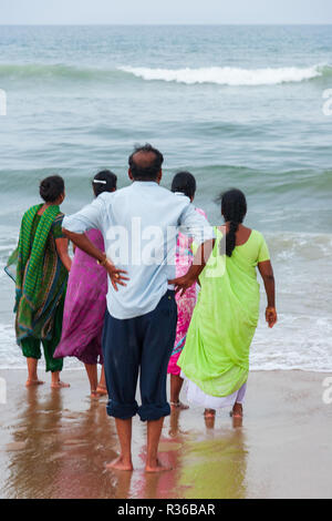 Chennai, Indien - 6. September 2007: Ein Mann und vier Frauen, barfuß, Blick auf die raue See in der beliebten Marina Beach in Chennai Stockfoto