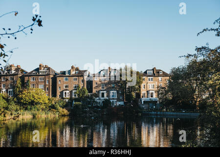 London, UK, 27. Oktober 2018: die Reihe der Halb-freistehende Häuser in Hampstead, mit Blick auf einen Teich in Hampstead Heath. Hampstead Heath umfasst 320 Hektar eines der Stockfoto