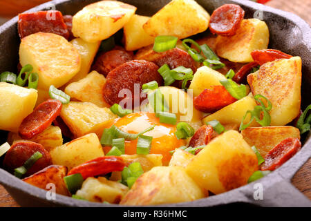Gebackene Kartoffeln mit Chorizo Wurst und Spiegelei in der Pfanne Stockfoto