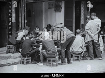 Schwarz-weiß Foto der Gruppe der chinesischen Männer spielen beliebtes Brettspiel mah-jong in der Stadt Dali China. Stockfoto