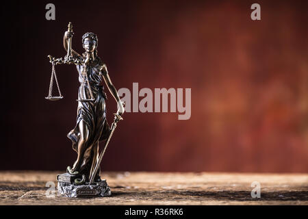 Lady "Justicia mit Schwert und Waage Bronze Figur auf hölzernen Tisch. Stockfoto