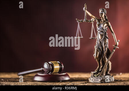 Lady "Justicia mit Schwert und Waage Bronze Figur mit Richter Hammer auf Holztisch. Stockfoto