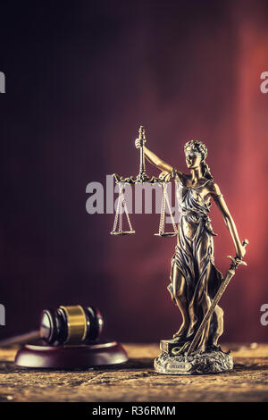 Lady "Justicia mit Schwert und Waage Bronze Figur mit Richter Hammer auf Holztisch. Stockfoto