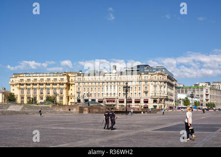 Moskau, Russland - August 9, 2018: Zwei Polizisten zu Fuß in Manezhnaya Platz in Moskau, Russland. Historisches Hotel National im Hintergrund. Stockfoto