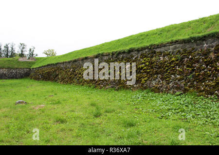 Eine Steinmauer mit künstlerischen Adern, über das Moos wächst. Viele Pflastersteine geklebt mit Zement. Karelien. Stockfoto