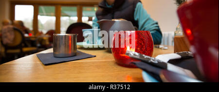 Panorama, Nahaufnahme von modischem, farbigem Geschirr auf dem Tisch in der trendigen britischen Bistro-Bar. Tee für zwei Personen wird in modernem Ambiente serviert. Stockfoto