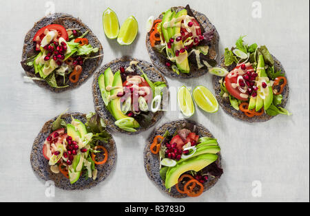 Glutenfrei vegan Tacos aus schwarzen Bohnen mit Tomaten und Avocado Salat mit tahini Sosse und Granatapfel Samen. Gesundes fast food für die ganze Famil Stockfoto
