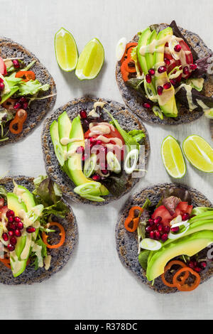 Glutenfrei vegan Tacos aus schwarzen Bohnen mit Tomaten und Avocado Salat mit tahini Sosse und Granatapfel Samen. Gesundes fast food für die ganze Famil Stockfoto