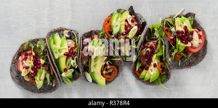 Banner von Glutenfreien veganer Tacos aus schwarzen Bohnen mit Tomaten und Avocado Salat mit tahini Sosse und Granatapfel Samen. Gesundes fast food für die w Stockfoto