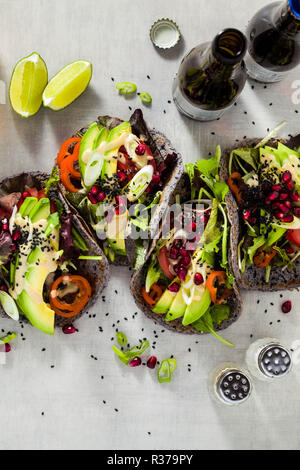 Glutenfrei vegan Tacos aus schwarzen Bohnen mit Tomaten und Avocado Salat mit tahini Sosse und Granatapfel Samen. Gesundes fast food für die ganze Famil Stockfoto