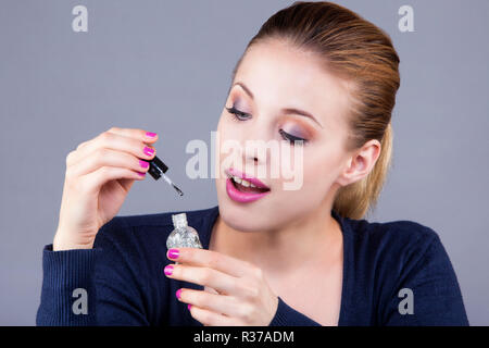 Porträt einer jungen Frau mit einem Nagellack mit einem überraschten Blick Stockfoto